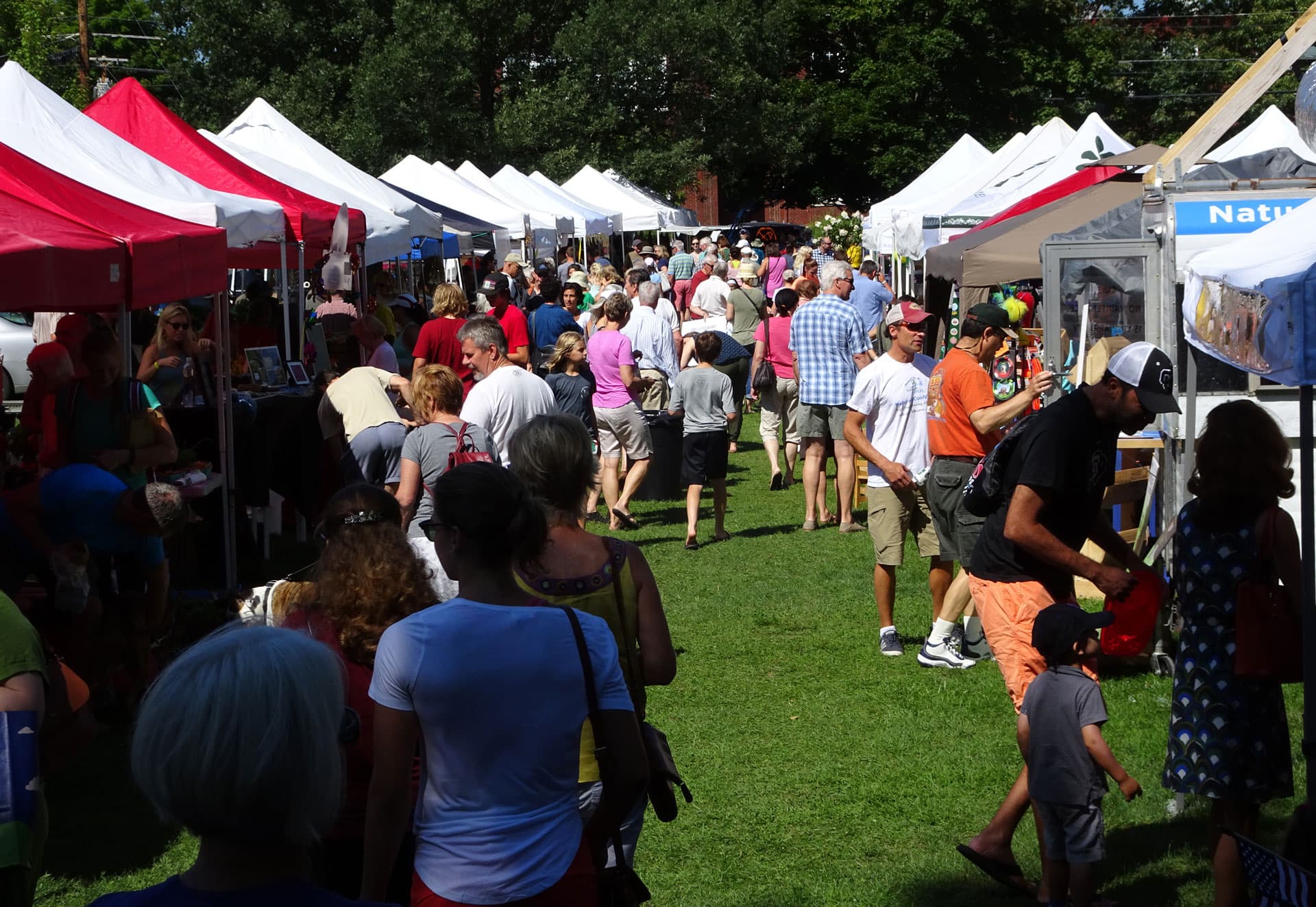 Visitors browsing vendor tents at the Shelburne Farmers Market